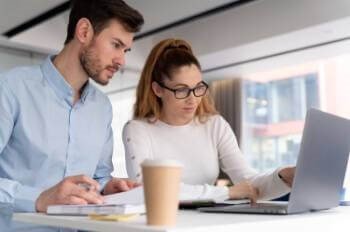 two people working at a laptop together