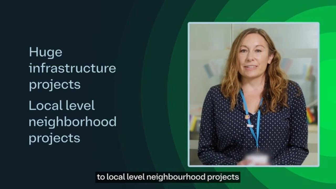 Woman speaking in a video beside text that reads: "Huge infrastructure projects. Local level neighborhood projects.