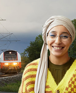 Smiling woman in front of a railway track and train, representing transportation or engineering.