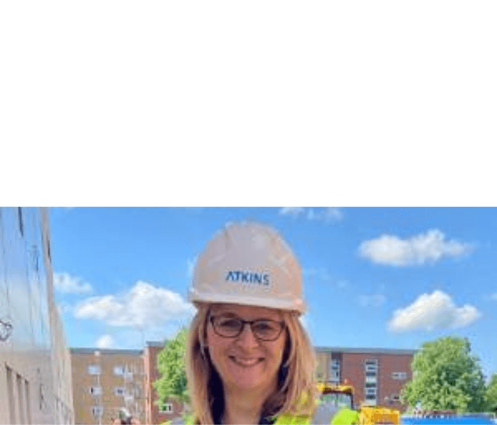 Woman in safety gear with Atkins hard hat on construction site