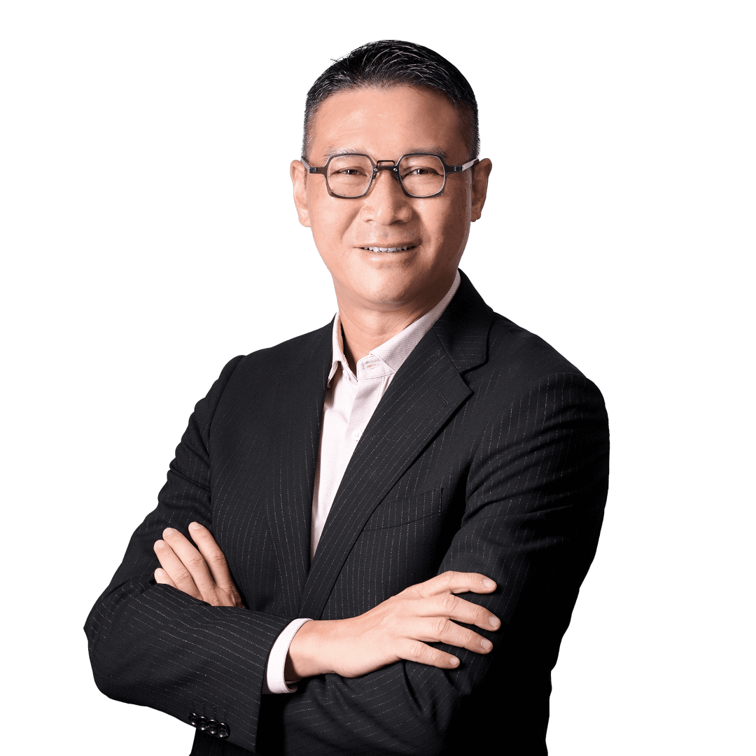 A man wearing glasses and a black pinstripe suit with a light-colored shirt, smiling and standing with his arms crossed against a plain background.