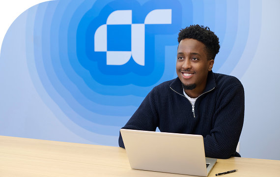 a boy sitting on the desk and giving live telecasting .