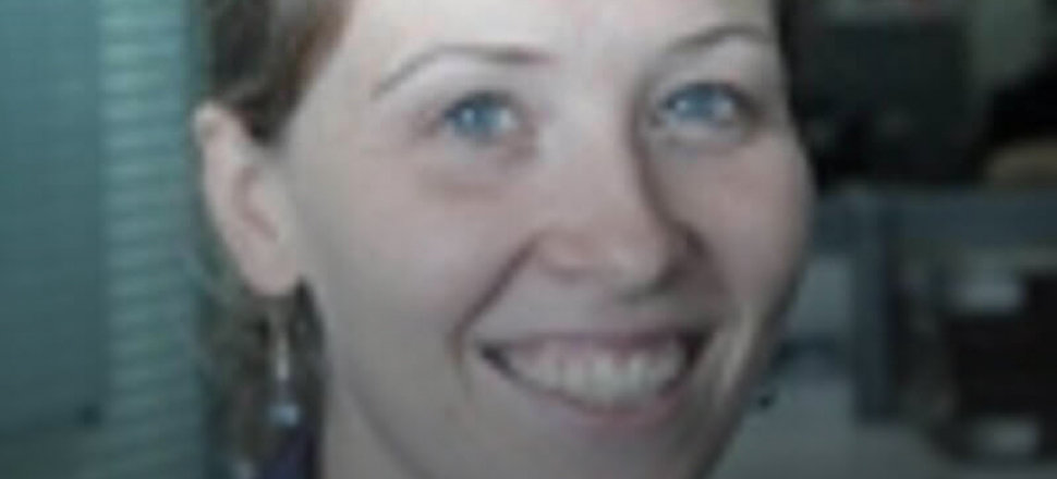 Smiling woman in a professional setting, partially blurred background