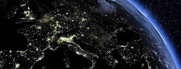 Satellite view of Europe at night showing city lights and Earth's curvature.
