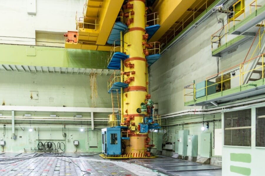 Interior of a nuclear power plant with a large yellow reactor refueling machine.