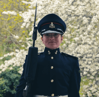 Person in military uniform smiling outdoors