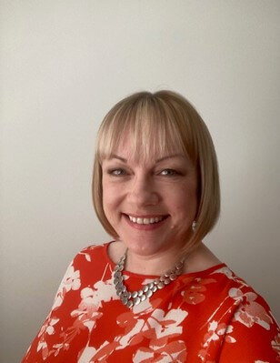 Woman in red shirt smiling indoors