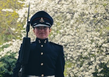 Person in military uniform smiling outdoors