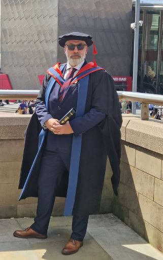 Photo of Dean in a graduation dress