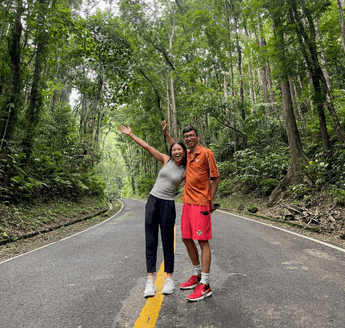 A picture of Michelle and her partner standing on a foresr road