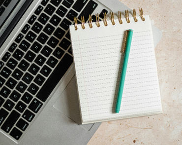 A notepad placed on a laptop