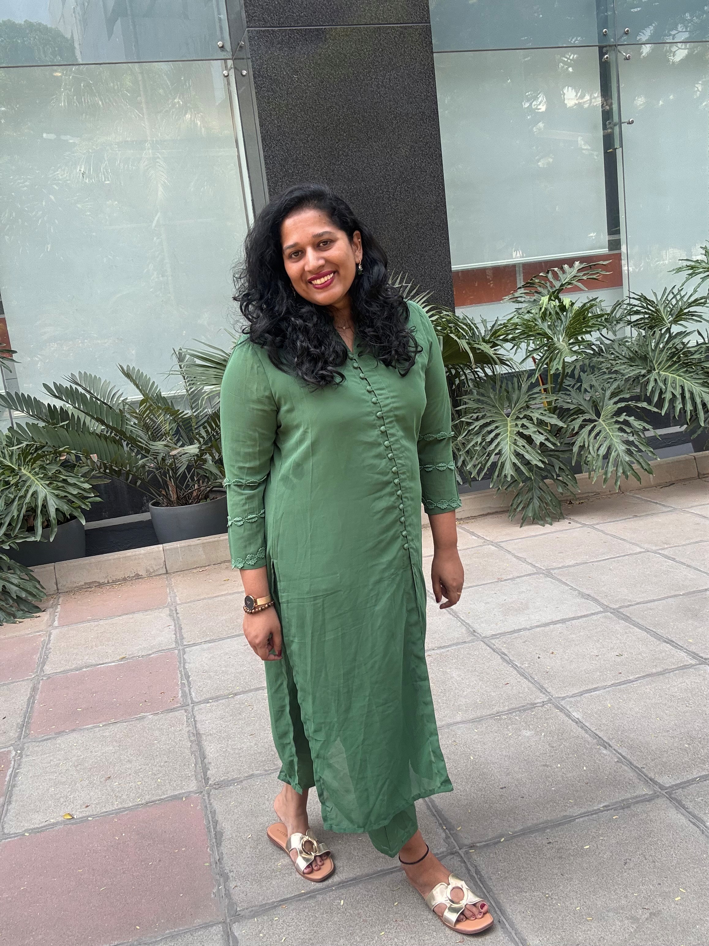 Ponnamma standing in green dress