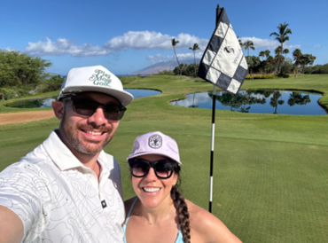 Selfie of Mike and his partner standing in a golf course 