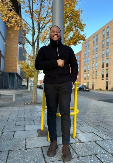 A picture of Caleb standing on a footpath with a beautiful tree behind him