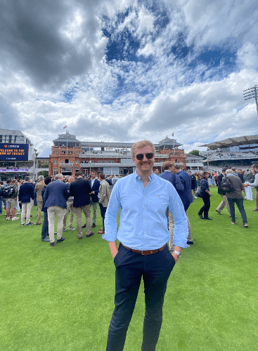 A casual picture of Matt staning on a cricket ground at an event
