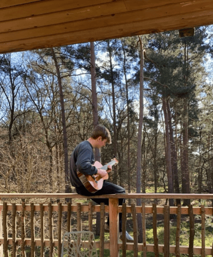 A picture of Rowen playing his guitar in his back yard
